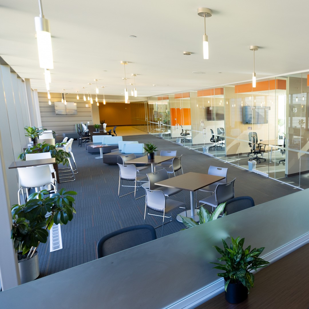 A wide shot of seating outside of offices with glass walls at the KU Innovation Park in Lawrence